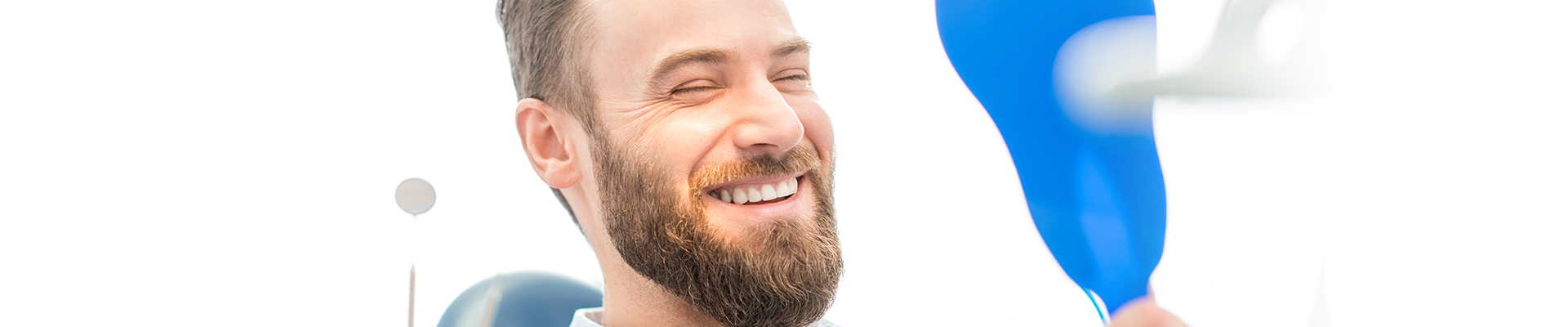 man with a beard with very white teeth smiling